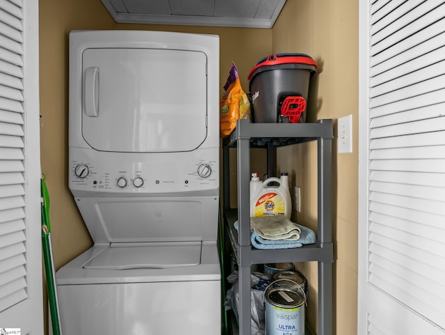 laundry area with stacked washer and dryer, laundry area, and ornamental molding