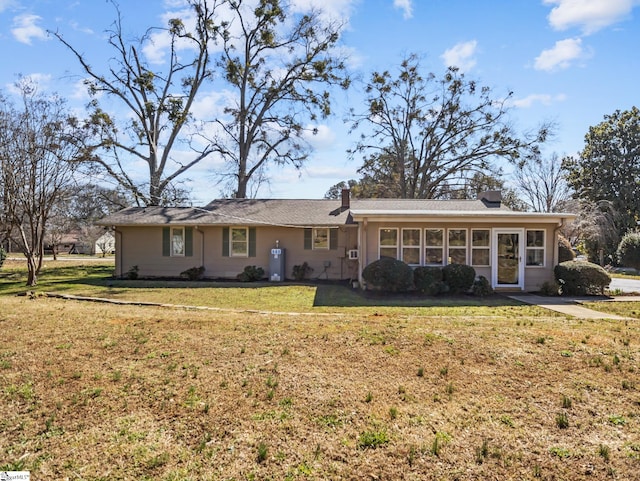 single story home featuring a front yard and a sunroom