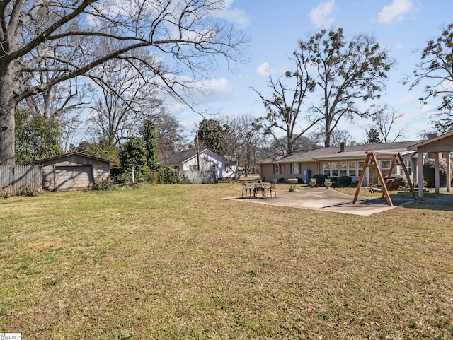 view of yard featuring a patio area, fence, and an outdoor structure