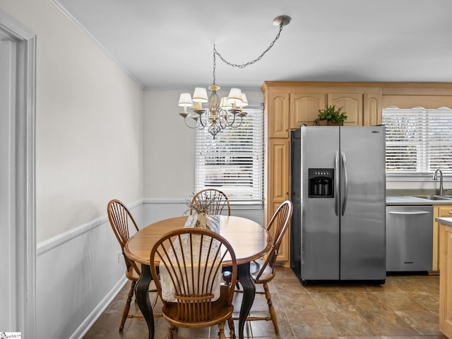 dining room featuring a chandelier, wainscoting, and crown molding