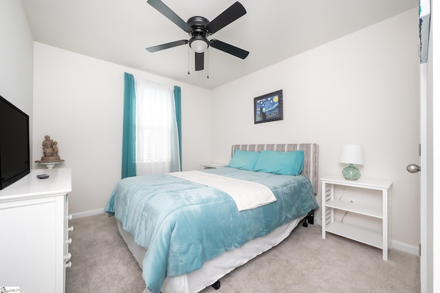 bedroom featuring light carpet, baseboards, and a ceiling fan