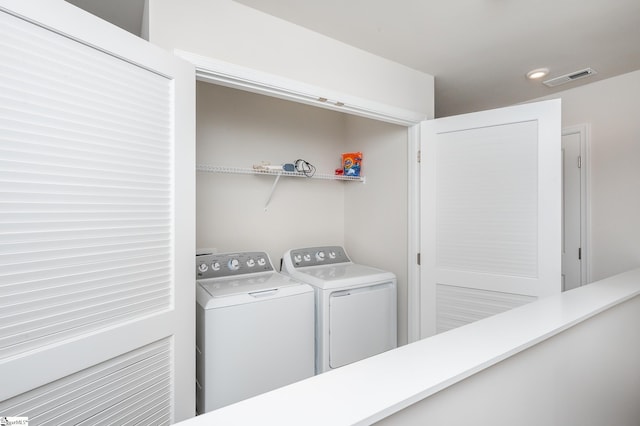 laundry room featuring laundry area, separate washer and dryer, visible vents, and recessed lighting