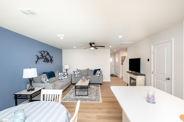 living area with a ceiling fan, recessed lighting, visible vents, and light wood-style floors