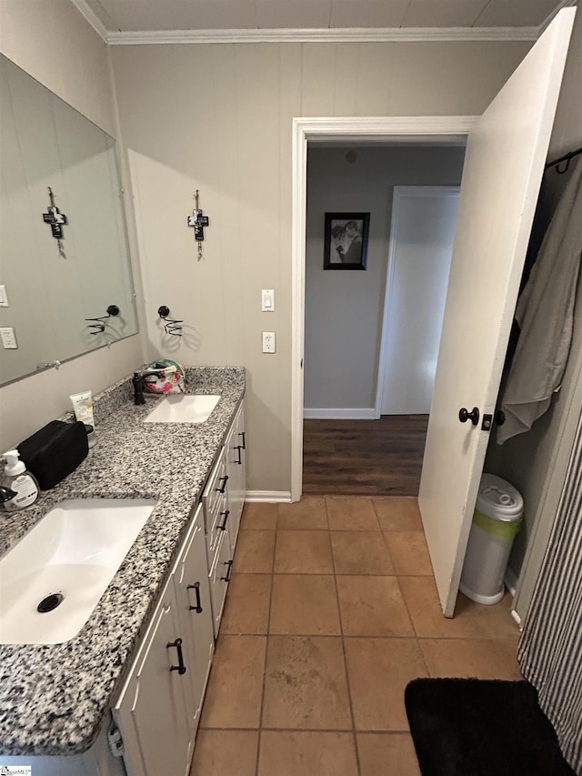 bathroom featuring double vanity, ornamental molding, a sink, and tile patterned floors