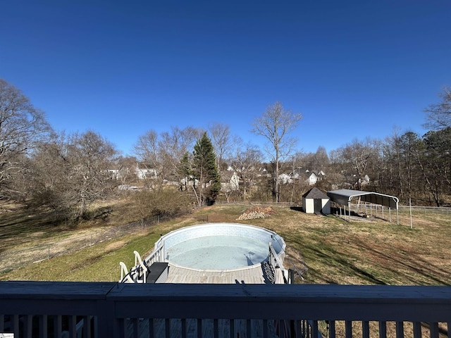 view of yard featuring an outbuilding, a storage shed, fence, and a jacuzzi