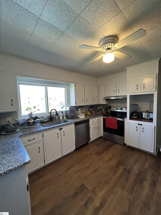 kitchen with dark wood-style floors, appliances with stainless steel finishes, white cabinetry, a sink, and under cabinet range hood