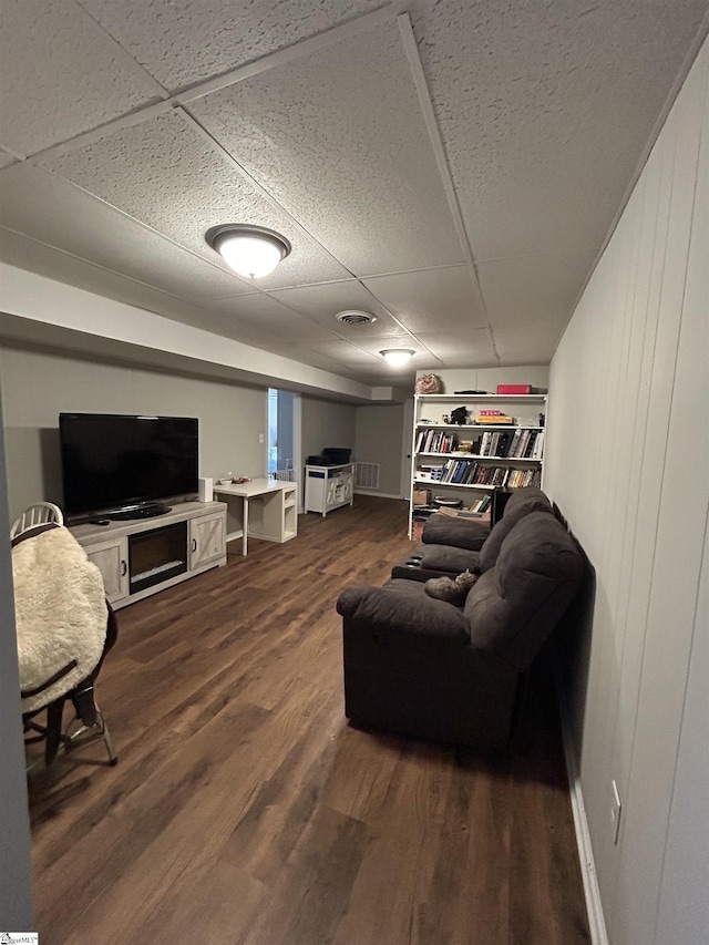 living area featuring visible vents, dark wood finished floors, and a drop ceiling