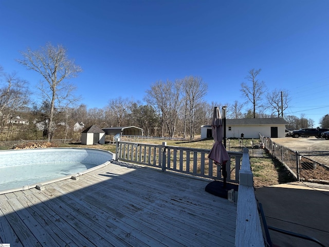 deck featuring a storage shed, fence, and an outdoor structure