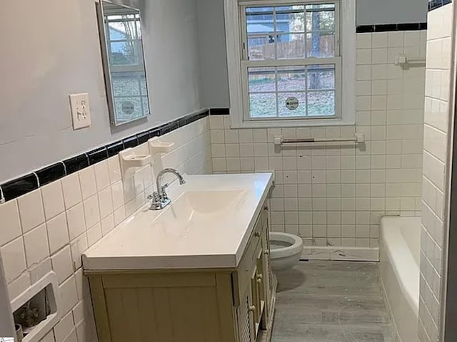 bathroom with tile walls, toilet, a bathing tub, vanity, and walk in shower