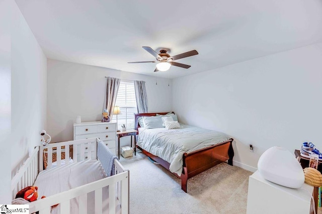 bedroom with light carpet, ceiling fan, and baseboards