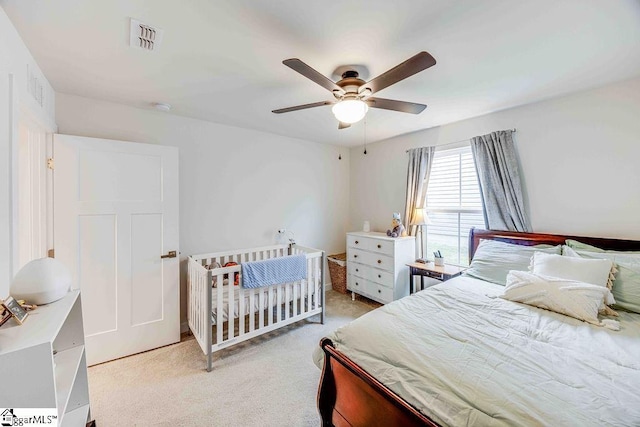 bedroom featuring visible vents, ceiling fan, and light carpet