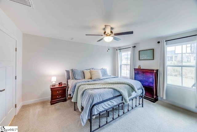 bedroom with visible vents, ceiling fan, light carpet, and baseboards