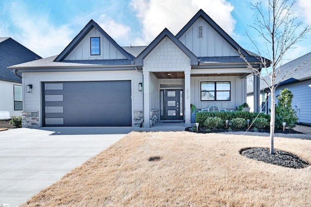 modern inspired farmhouse with driveway, a garage, stone siding, covered porch, and board and batten siding