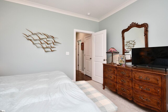 bedroom featuring light colored carpet and crown molding