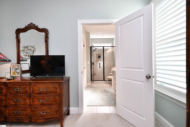 bedroom with baseboards, multiple windows, light tile patterned flooring, and light colored carpet