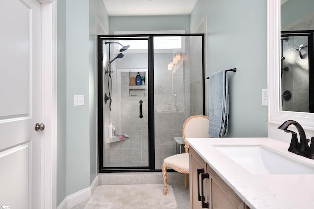 bathroom with toilet, a stall shower, and vanity