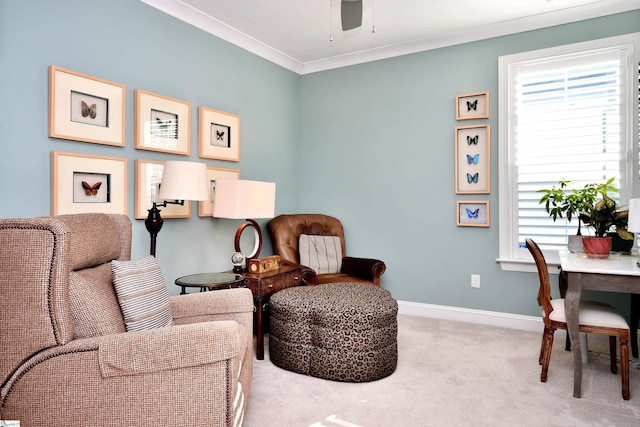 living area featuring carpet floors, ornamental molding, baseboards, and ceiling fan