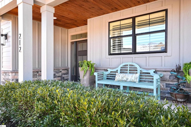 entrance to property featuring stone siding and a porch