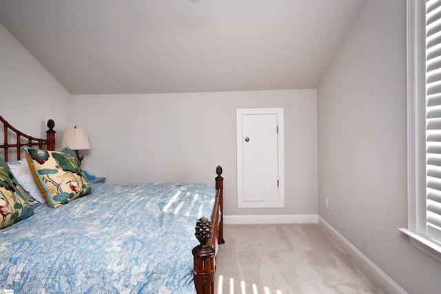 carpeted bedroom with vaulted ceiling and baseboards