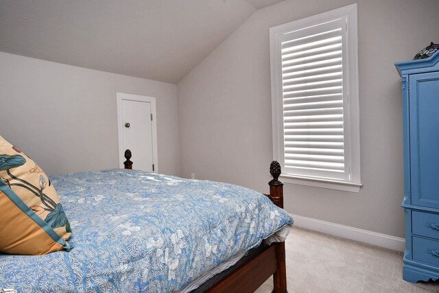 bedroom with light carpet, baseboards, and lofted ceiling