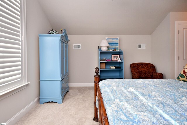 bedroom featuring lofted ceiling, baseboards, visible vents, and light colored carpet