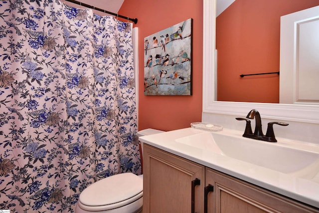 full bath with curtained shower, vanity, and toilet