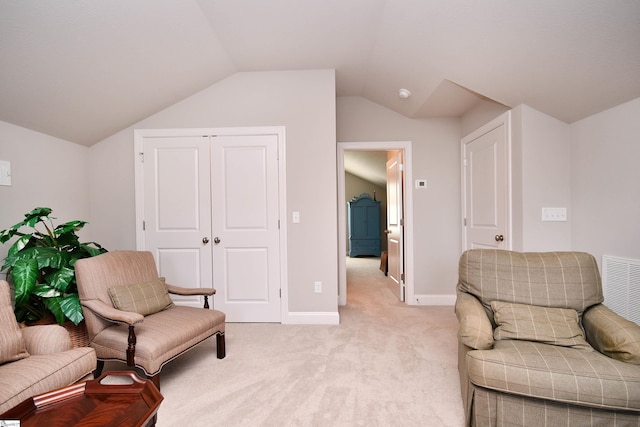 sitting room featuring light carpet, vaulted ceiling, visible vents, and baseboards