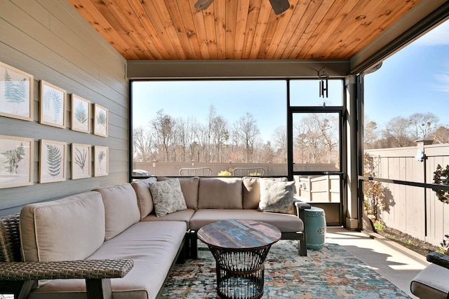 sunroom featuring wooden ceiling and a ceiling fan