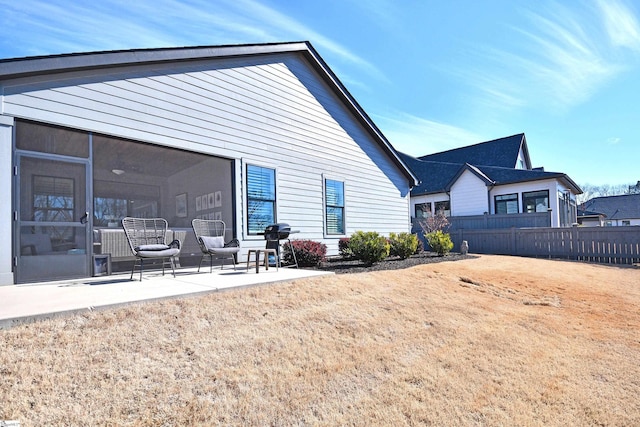 back of property with a patio area, fence, and a sunroom