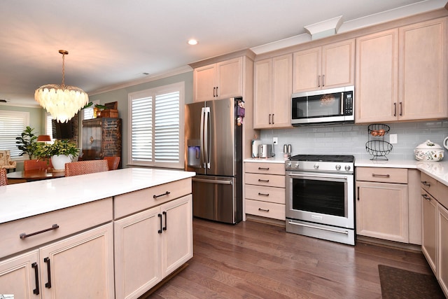 kitchen featuring decorative backsplash, dark wood-style floors, ornamental molding, stainless steel appliances, and light countertops