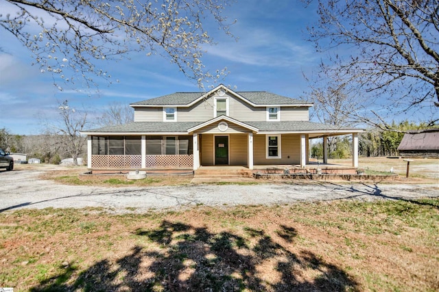 farmhouse inspired home with driveway, a porch, roof with shingles, and a sunroom