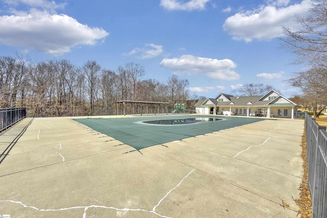 pool with a patio area and fence