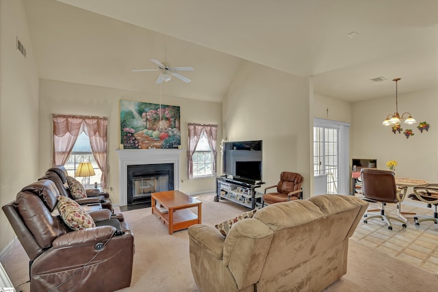 living room with a fireplace with flush hearth, visible vents, plenty of natural light, and high vaulted ceiling