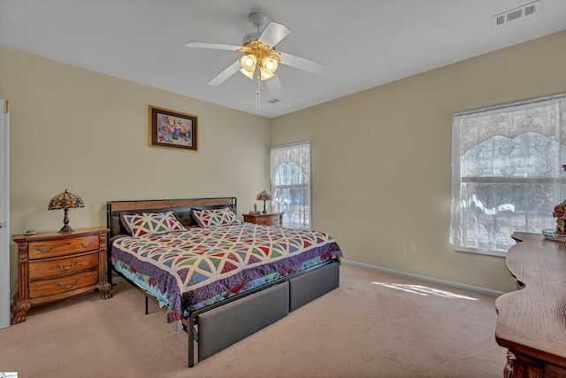 carpeted bedroom with a ceiling fan, visible vents, and baseboards