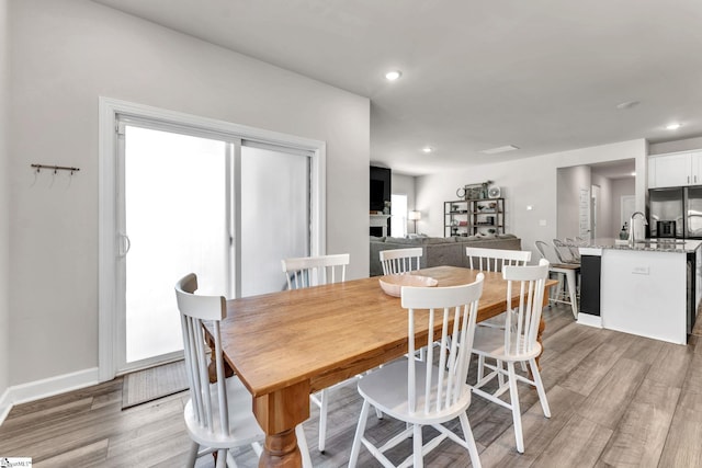 dining space featuring light wood-style floors, baseboards, and recessed lighting