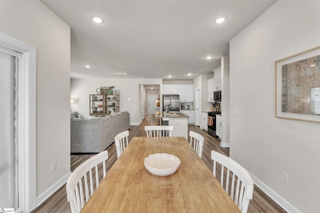 dining space with recessed lighting, baseboards, and wood finished floors