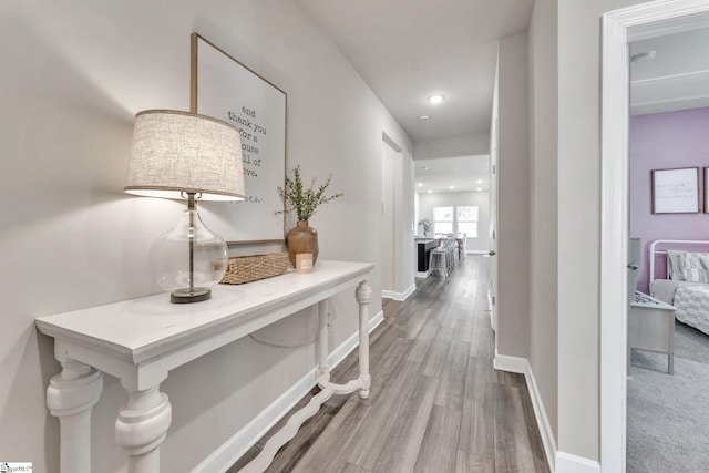 corridor featuring baseboards and wood finished floors