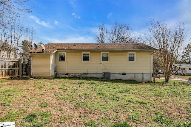 back of property featuring cooling unit, crawl space, fence, and a lawn