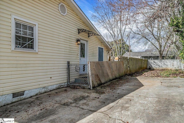 view of side of property with crawl space, a patio area, fence private yard, and a gate