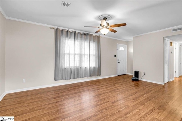 interior space with ornamental molding, visible vents, baseboards, and wood finished floors