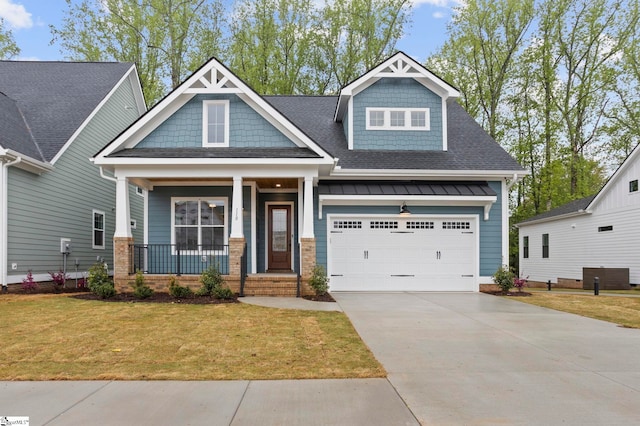 craftsman-style home with roof with shingles, a porch, concrete driveway, a front yard, and a standing seam roof