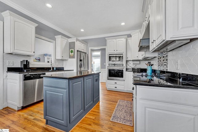 kitchen with stainless steel appliances, dark countertops, and white cabinets