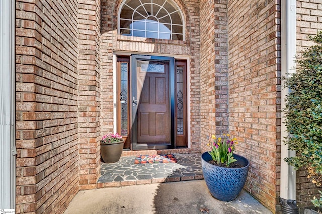 view of exterior entry featuring brick siding