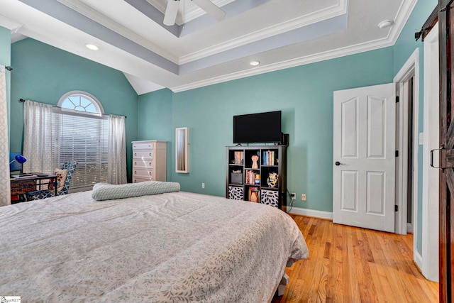 bedroom featuring light wood finished floors, baseboards, ornamental molding, and a raised ceiling