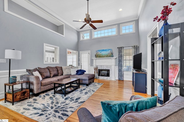 living room with a healthy amount of sunlight, crown molding, and wood finished floors