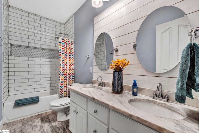 bathroom featuring toilet, wood tiled floor, double vanity, and a sink