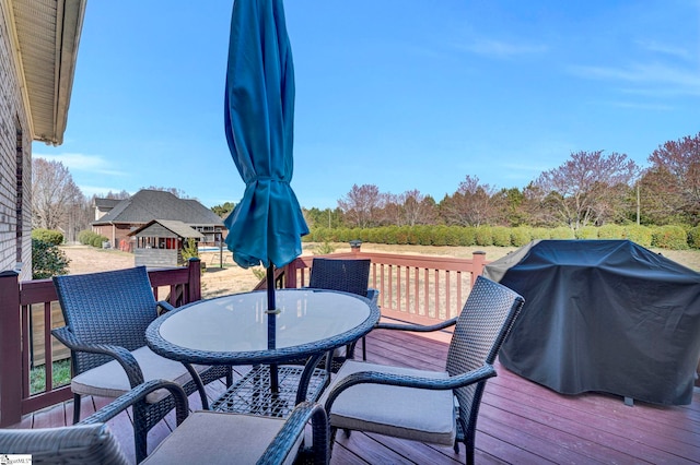 wooden deck featuring grilling area and outdoor dining area