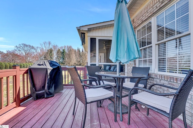 deck with outdoor dining space and area for grilling