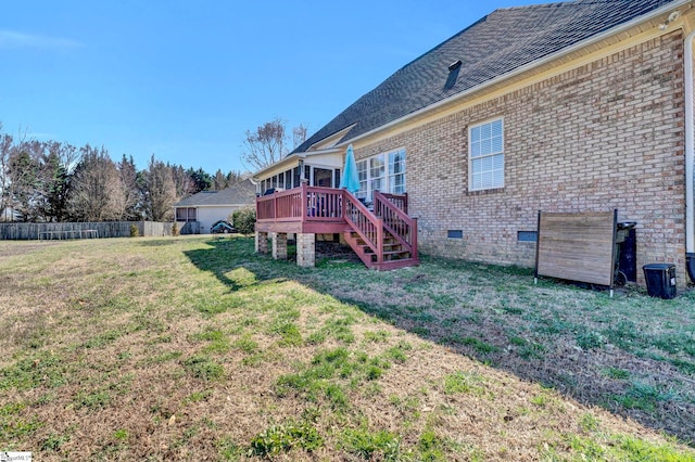 back of house with brick siding, crawl space, fence, and a lawn