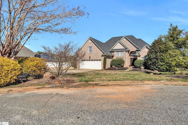 view of front of home with a garage, brick siding, and driveway